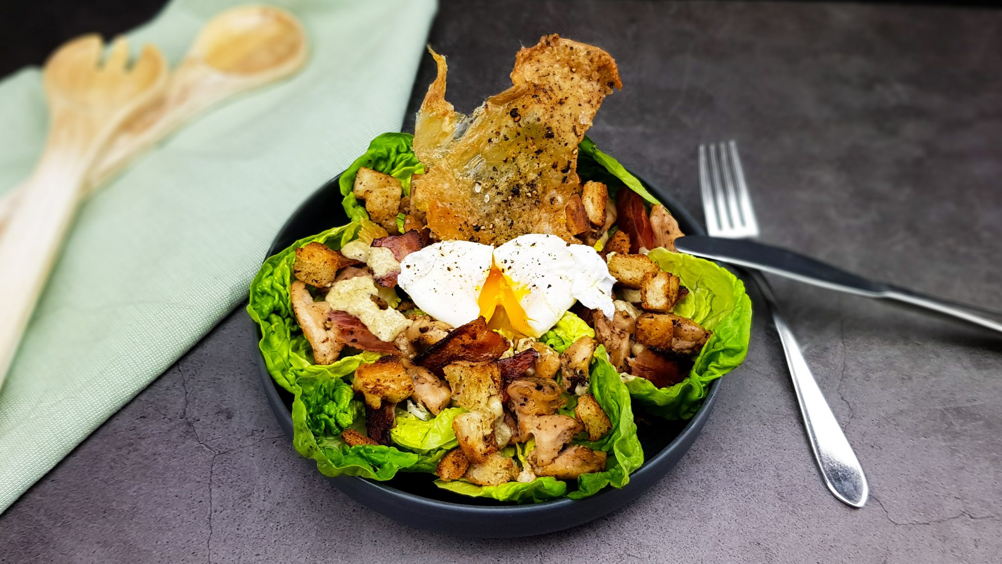 Caesar salade met een gepocheerd eitje en crispy kippenvel